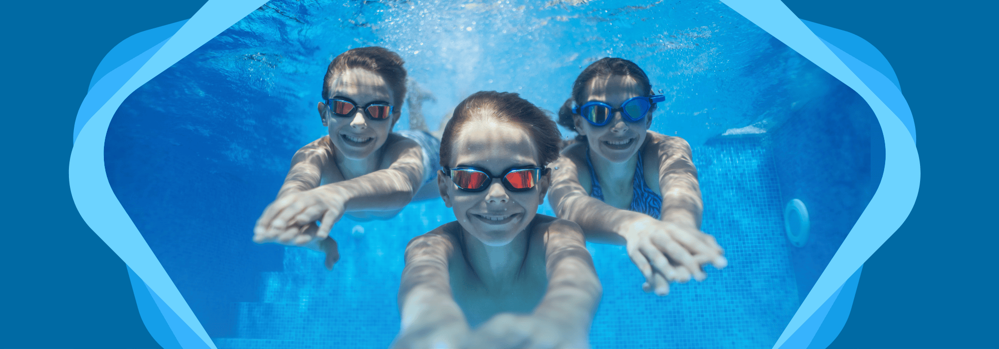 3 smiling children swimming underwater